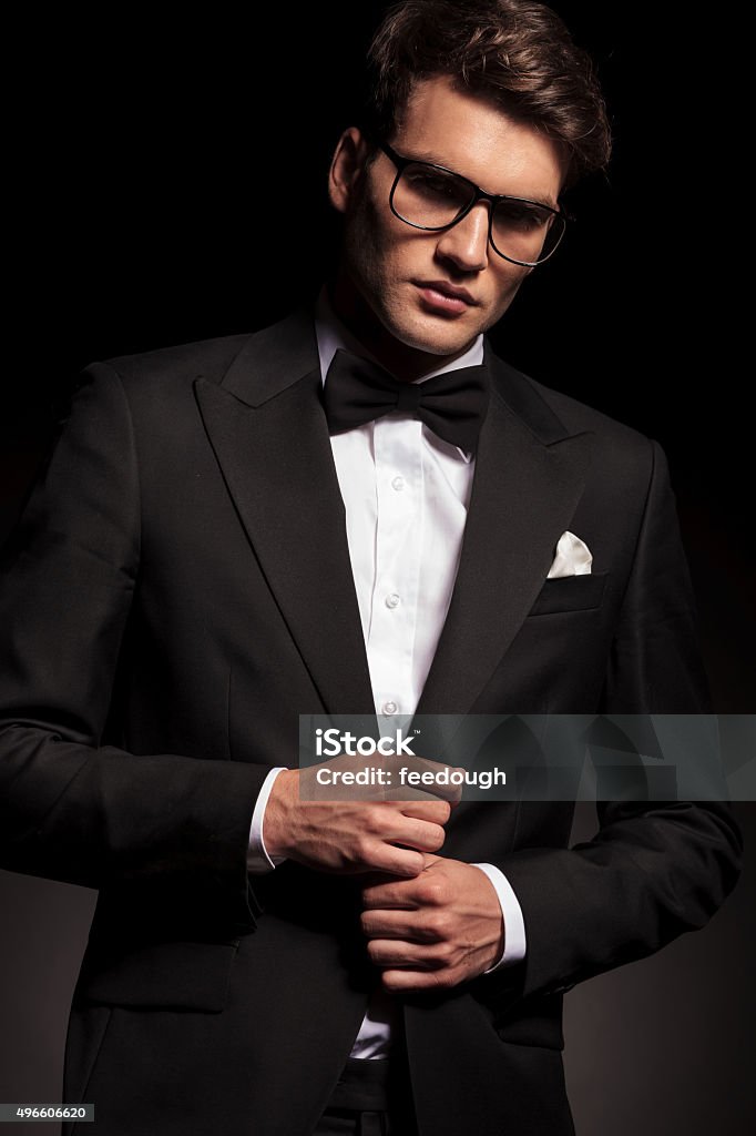 Handsome elegant man closing his jacket Handsome elegant man closing his jacket while looking at the camera. 2015 Stock Photo
