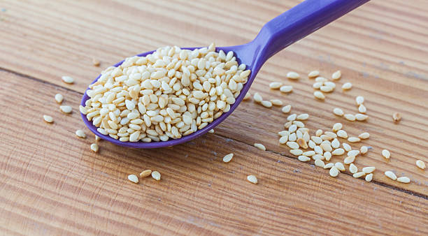 istock White sesame on purple ladle, wooden table, 496610684