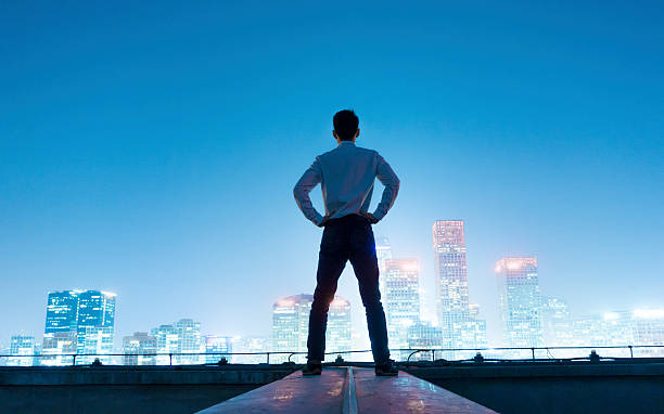 istock Businessman looking at cityscape at night 496611930
