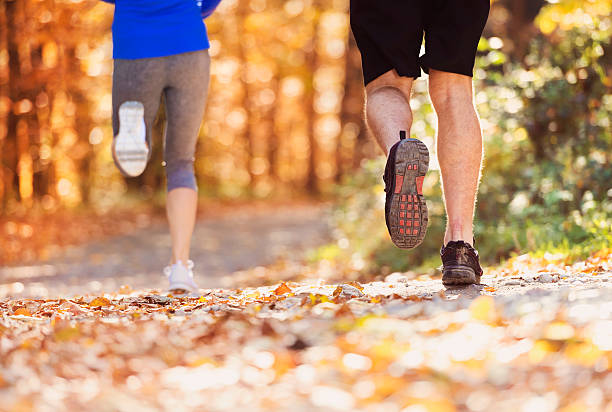 Beautiful couple running Beautiful couple running outside in autumn nature off track running stock pictures, royalty-free photos & images