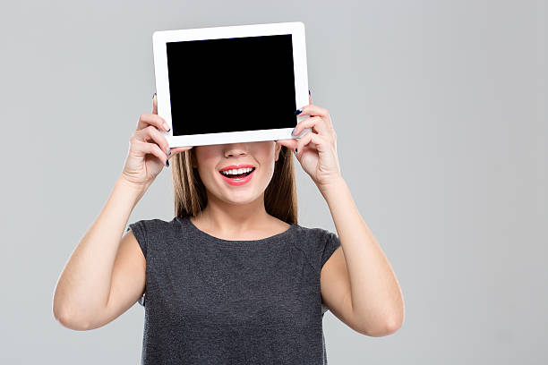 istock Woman covering her eyes with blank tablet computer screen 496614366