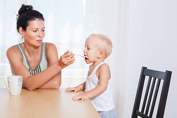 istock Beautiful angry mother feeding her little son, breakfast 496614932