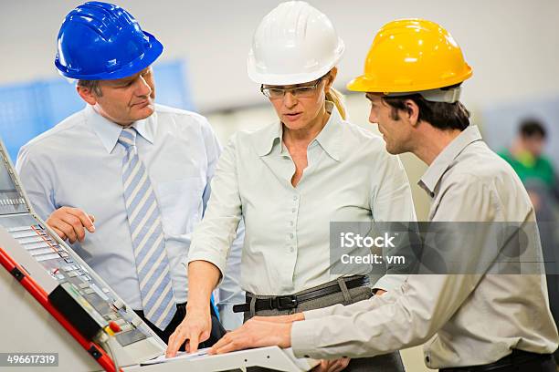 Engineers At The Manufacturing Plant Disscusing Project Stock Photo - Download Image Now