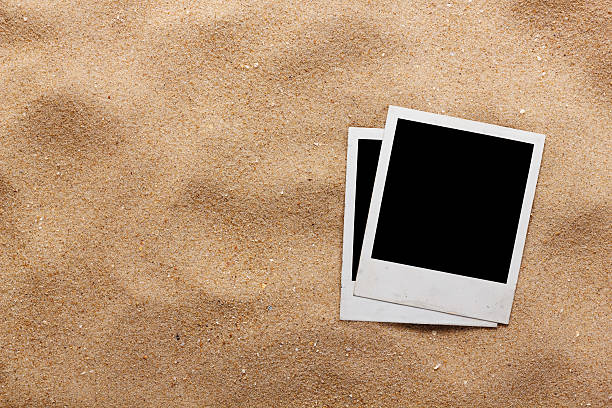 istock Old style empty photo cards lying on a sea sand 496617743