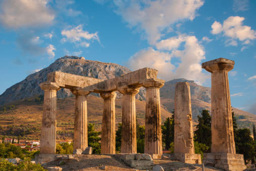 Ruins of Appollo temple with fortress at back in ancient Corinth, Greece