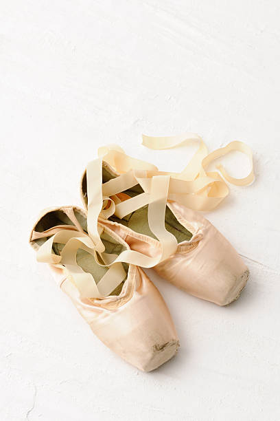 istock Old pink satin classical ballet slipper on plaster 496619611