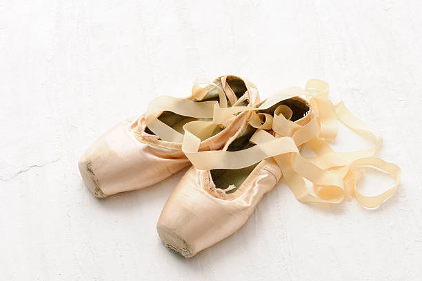 istock Old pink satin classical ballet slipper on plaster 496619613