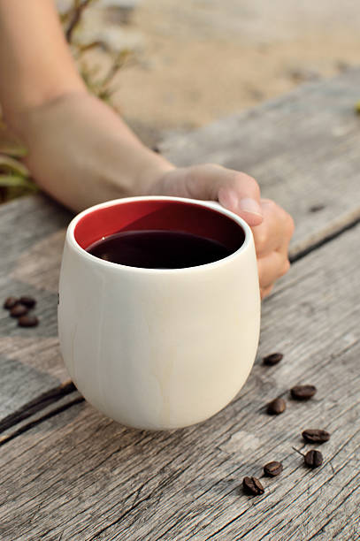 Women  hand holding a coffee cup, too soft focus