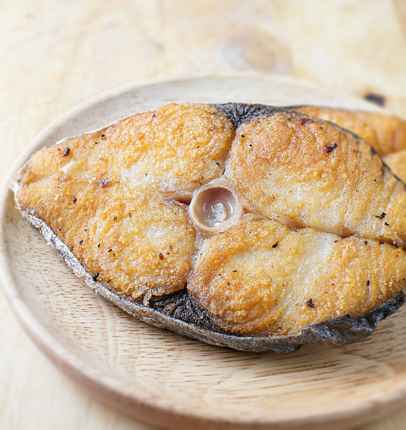 istock fried fish salted on wood dish 496630924