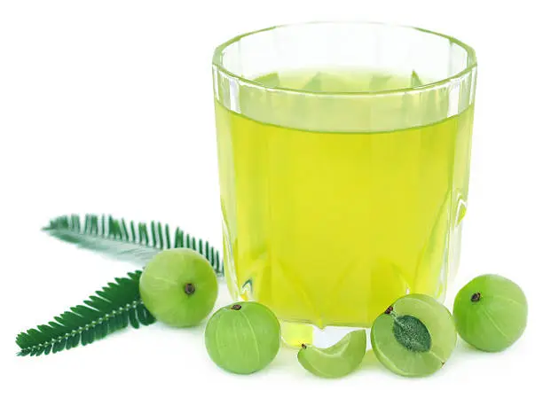 Herbal amla juice with fresh fruits over white background