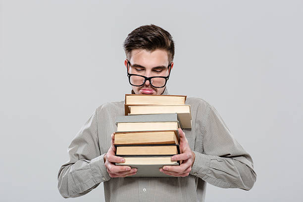 istock Exhausted student in glasses holding books 496632100