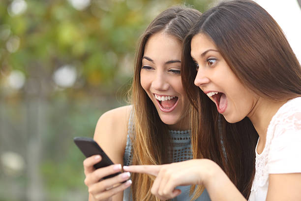 Euphoric friends watching videos on a smartphone