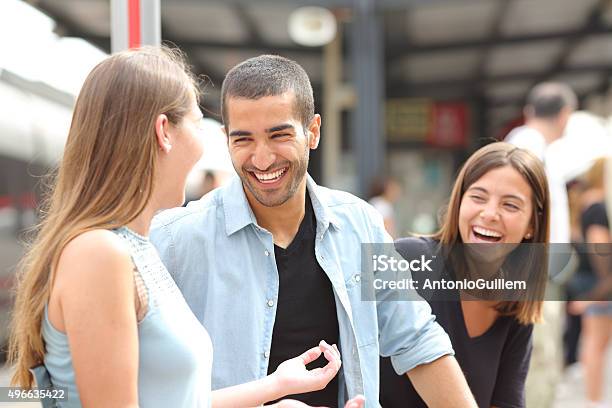 Three Friends Talking And Laughing In A Train Station Stock Photo - Download Image Now