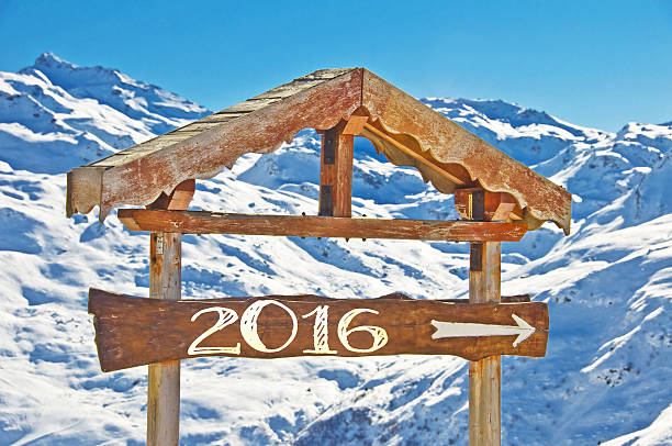 istock 2016 written on a wooden direction sign, snow  landscape 496639020