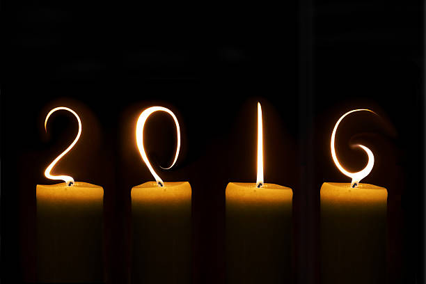 istock 2016 written with candle flames on black background 496639688