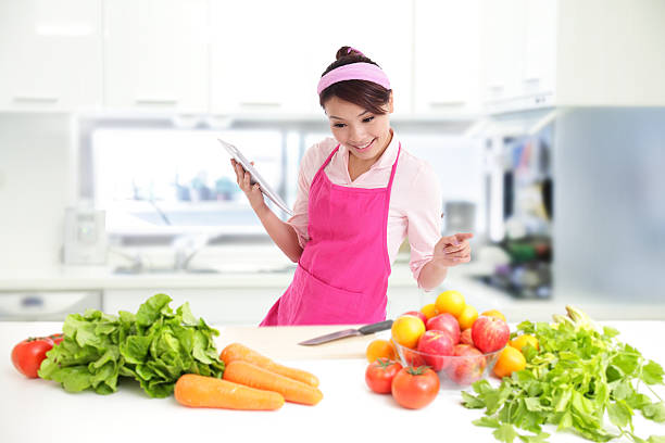 istock Young woman wearing kitchen apron with tablet 496646375