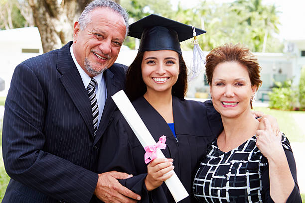 Hispanic Student And Parents Celebrate Graduation Hispanic Student And Parents Celebrate Graduation Smiling To Camera graduation photos stock pictures, royalty-free photos & images