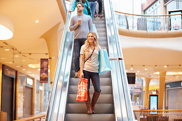 istock Female Shopper On Escalator In Shopping Mall 496648131
