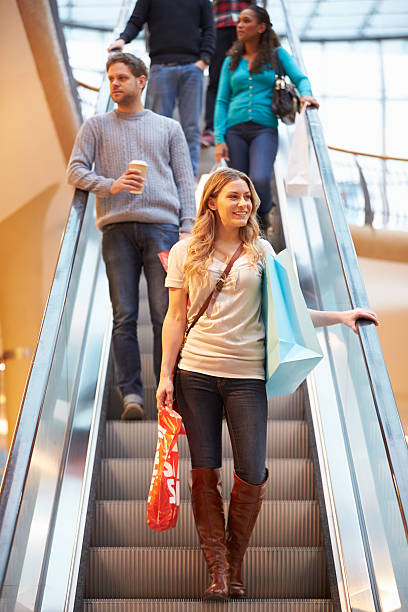 istock Female Shopper On Escalator In Shopping Mall 496648153