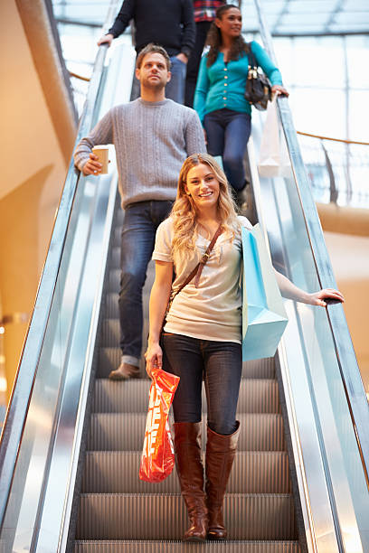 istock Female Shopper On Escalator In Shopping Mall 496648187