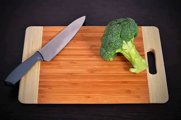 fresh green broccoli on a  chopping board and knife