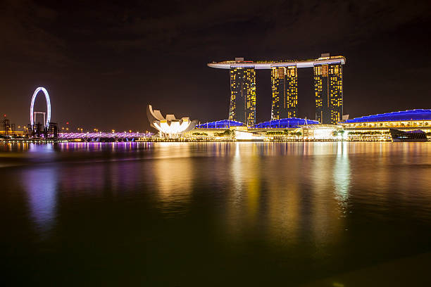 Singapore - Singapore June 1, 2014: Marina Bay Sands area,Helix Bridge and Ferris wheel in night.many travelers taking photo at the front of it.nowadays marina bay sands became the landmark of singapore.