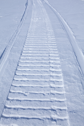 smooth snow with snowmobile trail cover in the winter sunlit