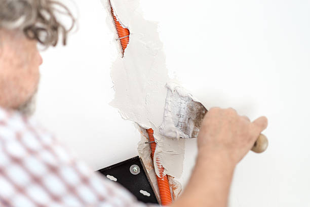 istock Electrician plastering recessed wiring in a wall 496652086