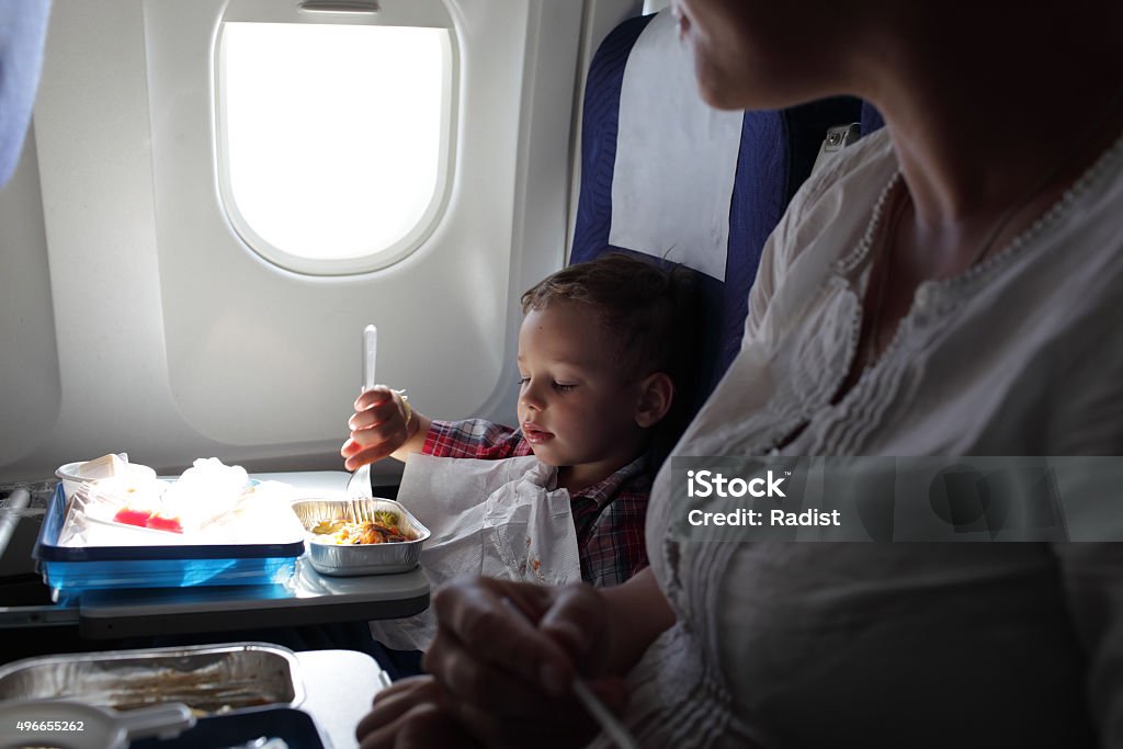 Mother and son have lunch Mother and her son have lunch on a flight Airplane Stock Photo