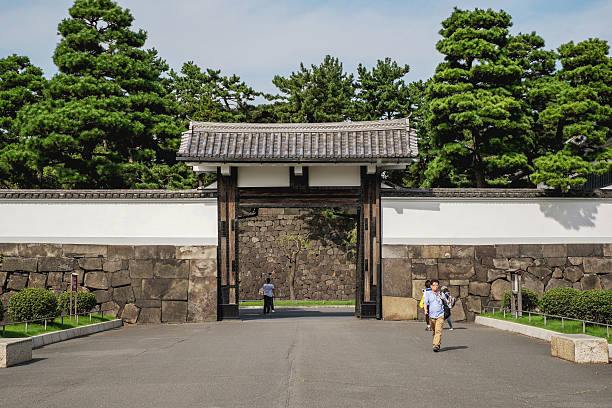 Tokyo, Japan - September 22, 2015: Tourists passing through gate to Imperial palace in Tokyo, the main residence of the Emperor of Japan. It is a large park-like area located in the Chiyoda ward of Tokyo.