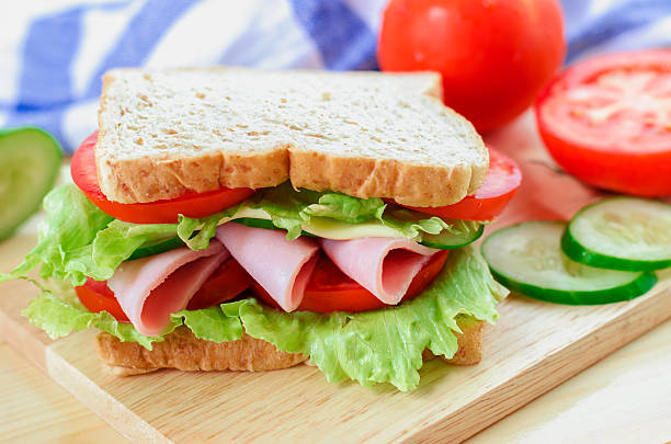 Close up of Healthy Sandwich on wooden board Close up of Healthy Sandwich on wooden board with cucumber and tomato baloney stock pictures, royalty-free photos & images