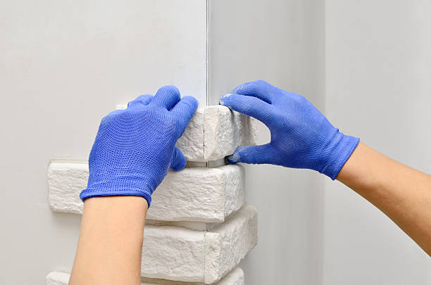 istock Facing wall decorative tiles, workers in blue glove 496658754