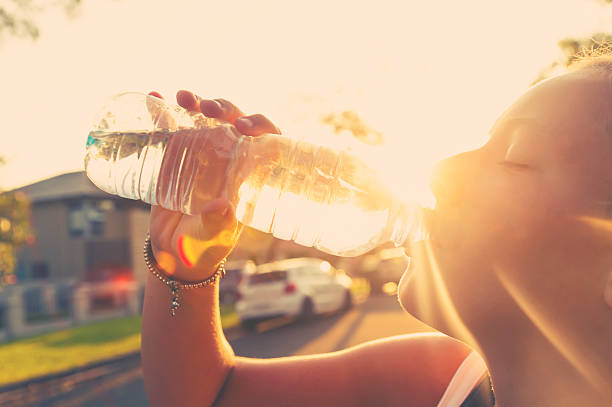Woman athlete drinking water from a bottle