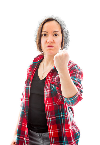 Young angry woman with fist up isolated on white background Young angry woman with fist up isolated on white background punching one person shaking fist fist stock pictures, royalty-free photos & images