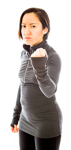 Young angry woman with fist up isolated on white background Young angry woman with fist up isolated on white background punching one person shaking fist fist stock pictures, royalty-free photos & images