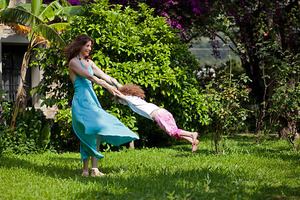 Mother and daughter are enjoying on grass at park