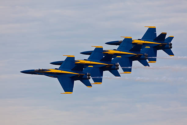 US Navy Blue Angels flying in formation Pensacola, USA - November 12, 2011: US Navy Blue Angels flying in formation on November 12, 2011 during the Blue Angels Homecoming Air Show at NAS Pensacola. Blue Angels fly F-18 Hornets with special livery celebrating colors of US Navy: Yellow and Navy Blue. US Navy Blue Angels is the oldest active military aerobatic demonstration squadron and is considered the best Demonstration Squadron in the world. supersonic airplane editorial airplane air vehicle stock pictures, royalty-free photos & images