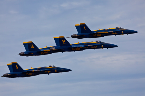 Pensacola, USA - November 12, 2011: US Navy Blue Angels flying in formation on November 12, 2011 during the Blue Angels Homecoming Air Show at NAS Pensacola. Blue Angels fly F-18 Hornets with special livery celebrating colors of US Navy: Yellow and Navy Blue. US Navy Blue Angels is the oldest active military aerobatic demonstration squadron and is considered the best Demonstration Squadron in the world.