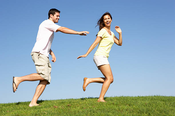 istock Young couple running through field 496666939
