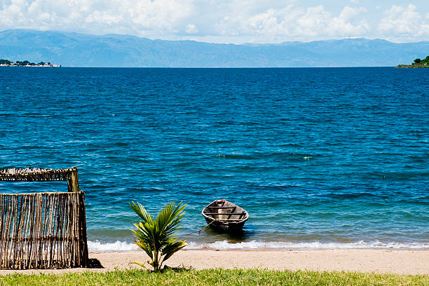 Monkey Bay or Lusumbwe, Cape Maclear / Chembe, Malawi: sandy beach and tranquil and warm waters of Lake Malawi / Lake Nyasa - Nankumba Peninsula, with Cape Maclear in the background.