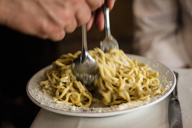 istock Saucing and Mixing Pasta at a Restaurant Table, Italy 496667823