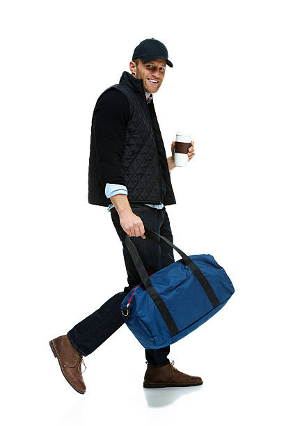 istock Happy man walking with gym bag and disposable cup 496668207