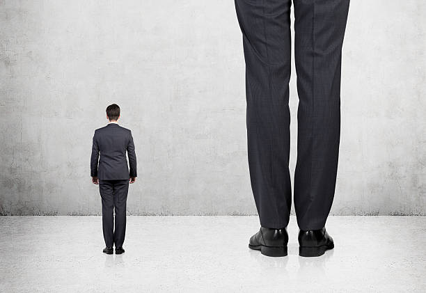 Rear view of two professionals Rear view of two professionals in formal suites who stand in front of concrete wall. tall person stock pictures, royalty-free photos & images