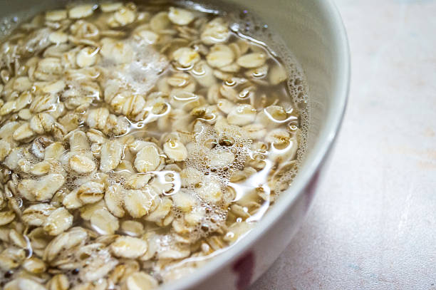 Soaking Jumbo Traditional Rolled Oats in a Bowl Soaking some traditional rolled oats in a bowl, to be prepared for eating. drenched stock pictures, royalty-free photos & images