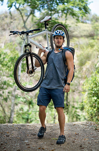 istock Mountain biker carrying a bike on his shoulders 496680036