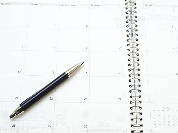 istock Calendar page in organizer and a pen as background 496682503
