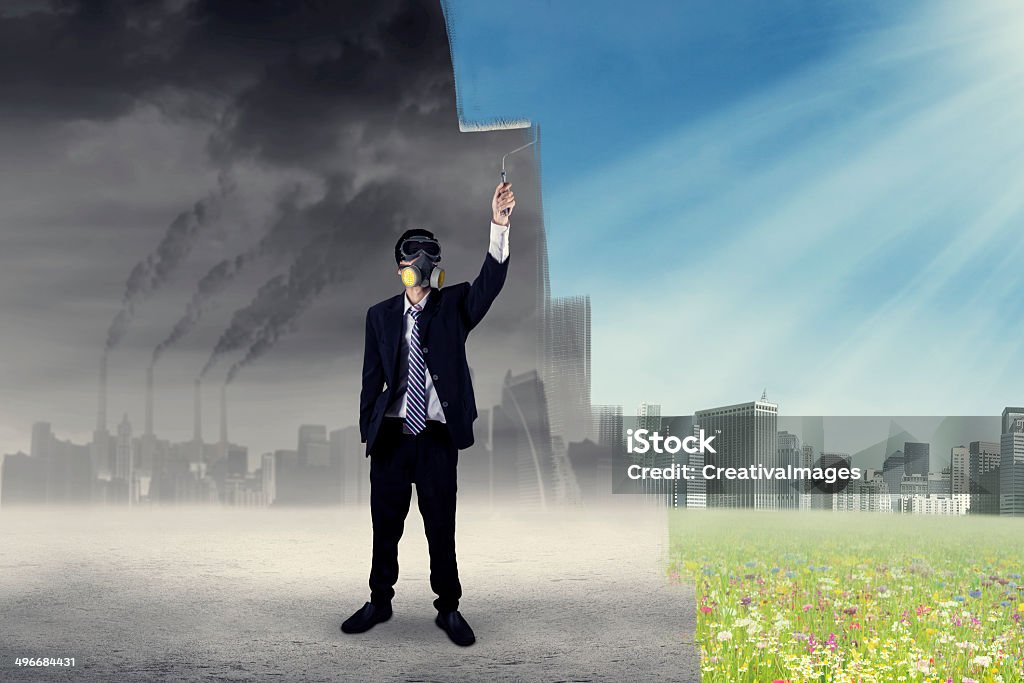 Businessman drawing a green city Businessman drawing a green city from a city with air pollution Adult Stock Photo