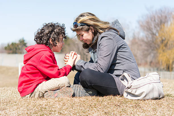 istock Mother and son praying outdoors 496684514