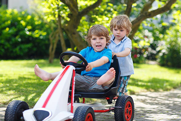 istock Two happy sibling boys playing with toy car 496685567