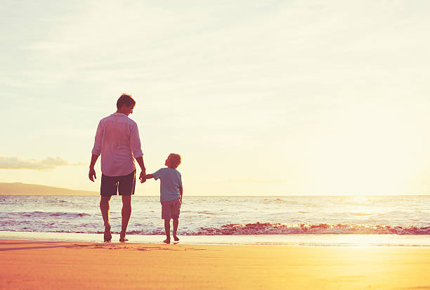 istock Father and Son Walking Together Holding Hands 496687318